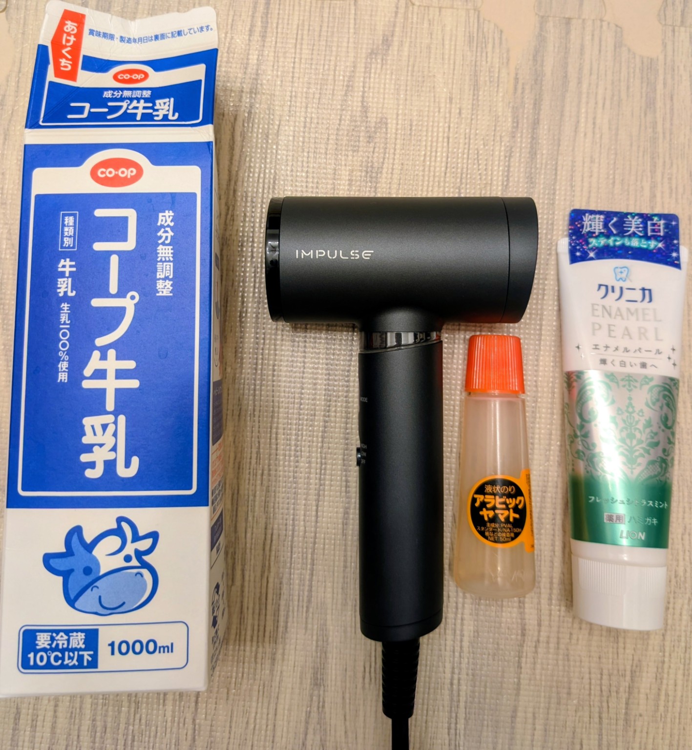 コイズミ インパルス KHD-B200を1L牛乳パック、歯磨き粉、アラビックヤマトと並べたサイズ比較